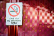 © Austockphoto - This is a no smoking area sign on red bus stop shelter