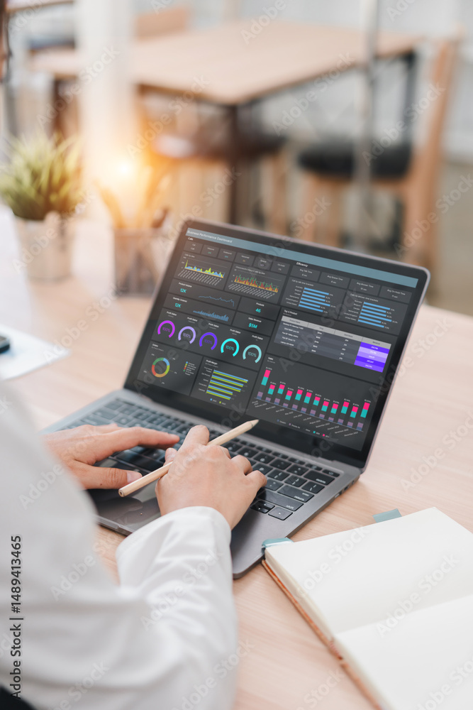 Business professional working on laptop with data analysis dashboard ...