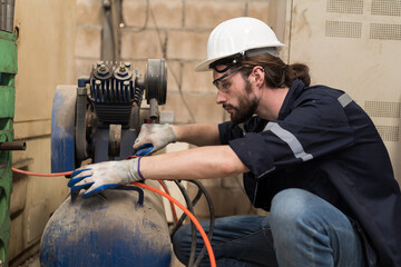 Leinwandbilder - Engineer worker setup, maintain, repair mechanism of operation of air compressor in industry factory. Male engineer worker working with air compressor machine