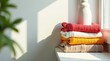 © napak - Stack of folded sweaters on a windowsill bathed in sunlight with a bottle