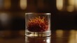 © mas - Saffron threads in glass, bar background, culinary ingredient
