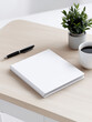 © Niamat - Blank Square Book Mockup on Wooden Desk with Pen, Coffee, and Plant – Minimal Workspace Scene