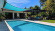 © Nabila Ayu - Luxurious backyard with modern pergola, vibrant swimming pool and sun shade sail
