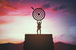 © Who is Danny - Silhouette of business person holding target symbol on top of steps with sunset background representing success and achievement concept.