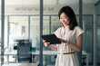 © Stock 4 You - Young middle-aged manager businesswoman using tablet pc application for online work in office. Asian woman banker holding digital pad tab computer, working on financial banking report. Copy space