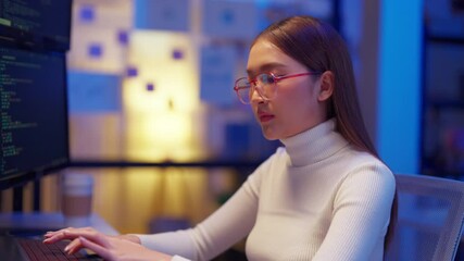 asian female programmer sits a dark tech workspace at night, fully focused on developing an online project. She writes HTML scripts and code for a modern website while contributing to automation work	