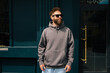 © San4ezz007 - Bearded hipster in dark grey hoodie and sunglasses – urban apparel mockup