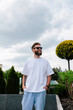 © San4ezz007 - White T-shirt on a bearded hipster in sunglasses — urban mockup for brands