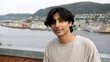 © Yopi - Portrait of a Young Middle Eastern Man with Shoulder-Length Black Hair Against a Scenic Waterfront