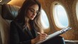 © photoplotnikov - Business Woman Working on Airplane