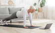 © Prostock-studio - Domestic Training. Active Senior Woman Making Plank Exersise In Front Of Laptop At Home, Free Space