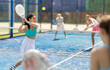 © JackF - Woman playing with other paddle tennis players. Tennis players participate in a tournament and hit balls to get points