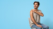 © Prostock-studio - Immunization Campaign. Vaccinated Young Man Showing Arm With Adhesive Bandage After Vaccine Injection And Looking Away, Smiling Guy Sitting On Chair Over Blue Studio Background, Panorama, Copy Space