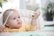 © splitov27 - Cute little baby eats food from a plate at a table