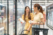 © Art_Photo - Young asian women shopping for dairy products from a refrigerator in grocery store, smiling enjoying healthy lifestyle choices selecting fresh milk together in supermarket chilled section