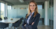 © Amir Bajric - Portrait of a professional woman in a suit standing in a modern office. Mature business woman looking at the camera in a workplace meeting area