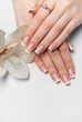 © Olena Rudo - Woman showing french manicure and white orchid flower