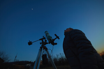 Wall Mural - amateur astronomer using telescope for watching stars, moon, planets and other celestial objects fro