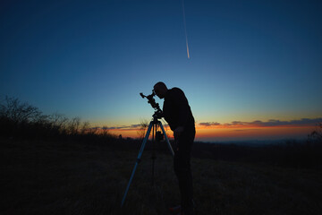 Wall Mural - amateur astronomer using telescope for watching stars, moon, planets and other celestial objects fro