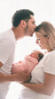 © Anna - Young family, man and woman holding a baby in their arms. Newborn concept.
