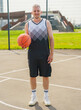 © muse studio - Excited basketball player poses on court with ball during sunny afternoon practice session