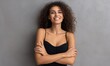 © underground - Woman smiling, arms crossed, against a gray wall; portrait for a beauty or fashion stock photo