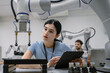© Nassorn - Hispanic engineer woman working on AI technology in robotics electronics engineering laboratory. University students' research project is programming robot machine with intelligent mechanical control