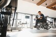 © Serhii - Man in wheelchair lifting weights during rehabilitation in gym