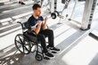 © Serhii - Man with disability, athlete lifting weights in wheelchair at gym for rehabilitation