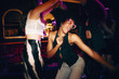 © Jacob Lund - Vibrant young adults dancing with joy in a lively modern nightclub setting