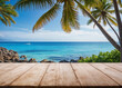 © bao - A tropical beach view with turquoise water, palm trees, and a wooden deck in the foreground.
