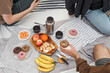 © Diana Light - Group of friends and a child enjoying a picnic outdoors. Sharing homemade food, drinks, and playing games on a sunny day. Warm emotions, connection, and authentic lifestyle