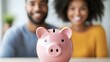 © pkproject - Happy couple saving money into a pink piggy bank at home