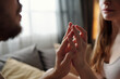 © pressmaster - Romantic couple sharing close, intimate moment with hands intertwined, basking in natural light from nearby window with blurred background enhancing their tender connection