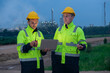 © Freeday photo - Two workers review project data at dusk in a construction site with industrial background