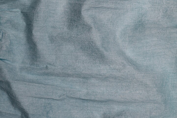 Poster - Smooth fabric drapes in soft blue color, showcasing textures under indoor lighting