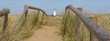© Paul - A wooden fence and board walk with a lighthouse in the background