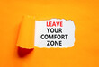 © Dzmitry - Leave your comfort zone symbol. Concept words Leave your comfort zone on beautiful white paper. Beautiful orange paper background. Business psychological Leave your comfort zone concept. Copy space.