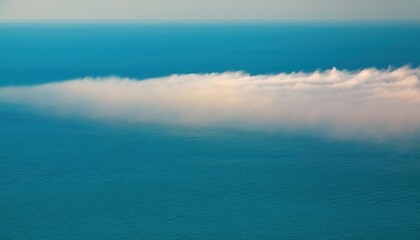Poster - aerial view of ocean surface blending into low coastal fog under clear blue sky for web design, nature branding, environmental print, minimalist background or atmospheric editorial layout

