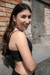 © Antonio - Young woman smiling and posing near brick wall