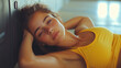 © Serge Sh. - Relaxed Young Woman In Yellow Sports Bra Resting With Pensive Expression Against Soft Background