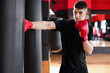 © New Africa - Boxing. Man practicing with punching bag in training center