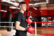 © New Africa - Man putting on protective boxing gloves in training center. Space for text