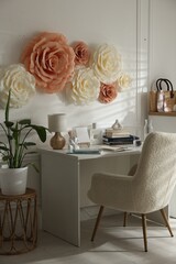 Poster - Beautiful decorative paper flowers on white wall and stylish furniture indoors