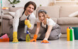 © Prostock-studio - Young happy couple in rubber gloves cleaning floor in their apartment and smiling at camera, washing flat with spray detergent and rag