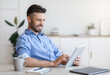 © Prostock-studio - Handsome Young Businessman Using Digital Tablet At Workplace In Office, Browsing New Application Or Social Media, Free Space