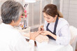 © Rakchanok - Young Asian female in apron applying nail polish to senior woman's hands. Engaged in conversation, showcasing a friendly and professional service, nail and spa small business entrepreneur working