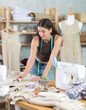 © JackF - Woman tailor makes chalk markings on the fabric before cutting. Process of sewing clothes in a sewing workshop