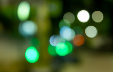Wall Mural - a blurry image of a city street with green and blue lights