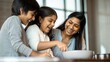 © Jo - Indian Family Laughing While Cooking Together in Modern Kitchen